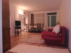 sala de estar con sofá rojo y TV en Five, en Luduş