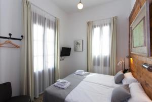 a bedroom with a large bed and two windows at Gran H La Marina in Altea