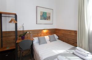 a bedroom with a bed and a desk with a chair at Gran H La Marina in Altea