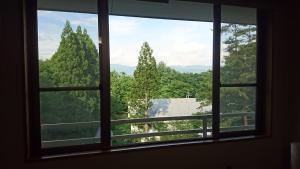 a window with a view of a lake and trees at Hotel Oak Forest in Hakuba