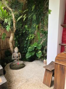 un giardino con una statua di scimmia seduta in una ciotola di White Lotus Oasis ad Ubud