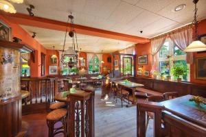 a restaurant with orange walls and tables and chairs at Hotel Deutscher Hof in Bad Wilsnack