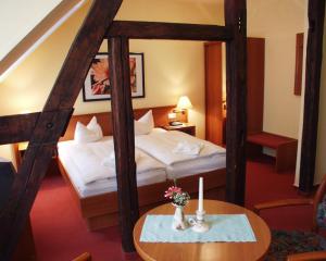 バート・ヴィルスナックにあるHotel Deutscher Hofのベッドとテーブルが備わるホテルルームです。