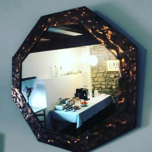 un miroir reflétant une chambre avec une table et une cafetière dans l'établissement Argonz Etxea, à Urzainqui