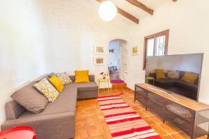 a living room with a couch and a large flat screen tv at Cubo's Casa Rural El Refugio in Alhaurín el Grande