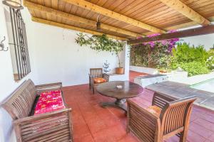 um pátio com uma mesa e cadeiras e uma piscina em Cubo's Casa Rural El Refugio em Alhaurín el Grande