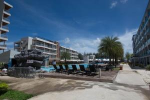 a group of chairs sitting next to a swimming pool at Grandblue Condominium 504 in Ban Phlong Takhe