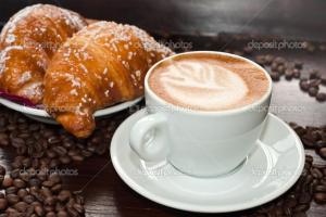 a cup of coffee and croissants and coffee beans at B&B Piazza Duomo in Cerignola