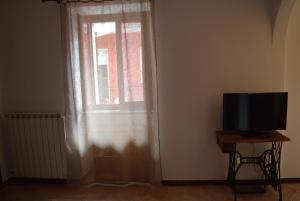 a room with a window with a television and a table at Le Quare in Gravellona Toce