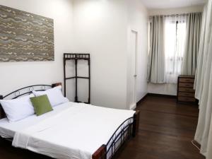a bedroom with a large white bed and a window at Balay 8 Suites in Silay