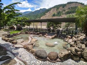 a pool of water with rocks and a gazebo at Fun Chen Resort Hotel in Liugui