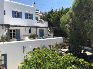 a view of a white house with blue shutters at Studios & Suites Rania in Mikonos