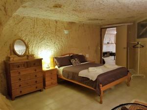 a bedroom with a bed and a dresser and a mirror at Underground Gem in Coober Pedy