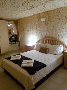 a bedroom with a large bed with towels on it at Underground Gem in Coober Pedy