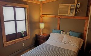 a bedroom with a bed and a window at Marius B&B & Hostel in Silang