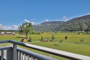 einen Balkon mit Blick auf ein Feld und die Berge in der Unterkunft Hotel Garni Zerza in Tröpolach
