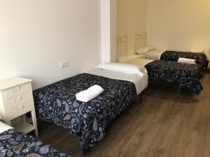 Posteľ alebo postele v izbe v ubytovaní Albergue-Pensión Cabo da Vila