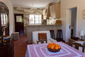una cocina con una mesa con un tazón de naranjas. en A Casa da Avó Ana, en Arneiro das Milhariças