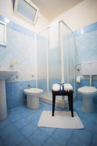 Baño azul con lavabo y aseo en B&B Terra Nobile - Portopalo, en Portopalo di Capo Passero