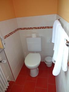 a bathroom with a white toilet and towels at Hotel Ricci in Rust