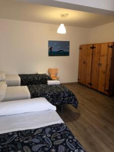 a hotel room with two beds and a cabinet at Albergue-Pensión Cabo da Vila in Finisterre
