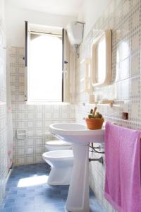 a white bathroom with a sink and a toilet at Residence Torre Preziosa in Vieste
