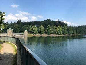 un puente sobre un río con árboles en el fondo en Ferienhaus Sauerland, en Herscheid