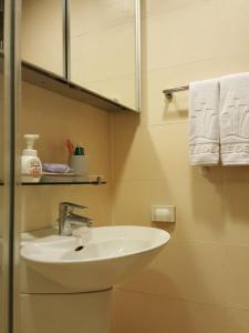 a bathroom with a sink and a mirror and towels at Haeundae Bada Condo in Busan