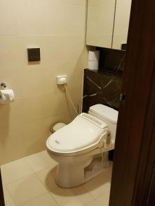 a bathroom with a white toilet and a sink at Haeundae Bada Condo in Busan