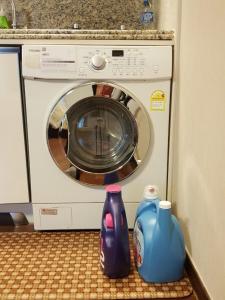 a washing machine with two vases sitting next to it at Haeundae Bada Condo in Busan