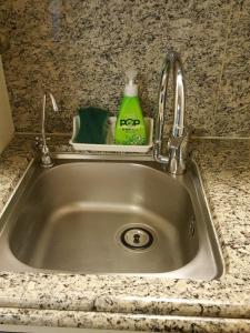 a kitchen sink with a faucet and a green detergent at Haeundae Bada Condo in Busan