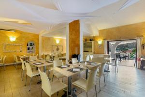 un restaurante con mesas y sillas en una habitación en Hotel Mon Repos, en Baja Sardinia