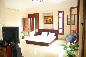 a bedroom with a bed and a flat screen tv at Hạ Long Lily Homestay in Ha Long