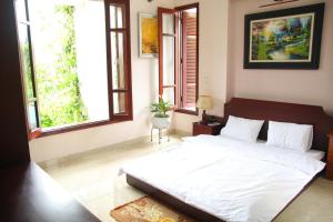 sypialnia z dużym białym łóżkiem i oknami w obiekcie Hạ Long Lily Homestay w Ha Long