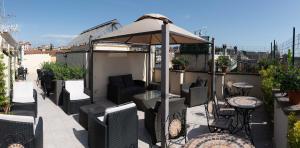 un patio con ombrellone, sedie e tavoli di Hotel Anfiteatro Flavio a Roma