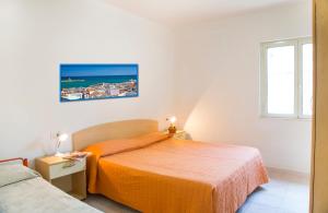 a bedroom with a bed with an orange bedspread at Residence Torre Preziosa in Vieste