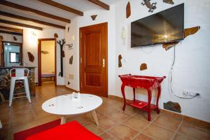 a living room with a table and a tv on the wall at Casa Checa Apartment 1 in Cotillo