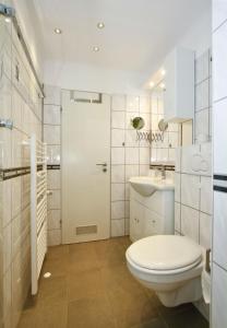ein weißes Bad mit einem WC und einem Waschbecken in der Unterkunft ferienwohnungen-bendler in Freyung