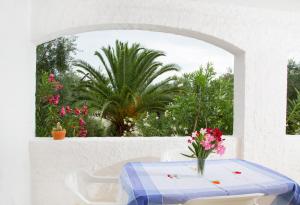 a table with a blue and white table cloth and flowers at Residence Torre Preziosa in Vieste