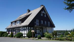 uma casa a preto e branco com um telhado de gambrel em Gästehaus Mira em Winterberg