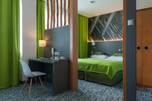 a room with a bed and a desk and a chair at Villa Park Med. & SPA in Ciechocinek