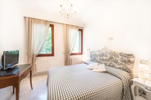 a bedroom with a bed and a desk and a tv at B&B Casa Baseggio in Venice