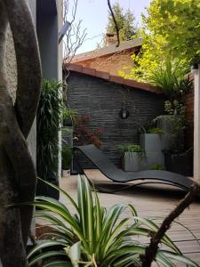 a patio with a bench and plants on a house at Au clair de lune in Chavelot