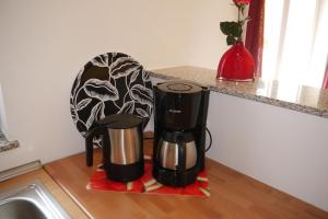 two coffeemakers sitting on a counter next to a sink at Ferienwohnung ALEXA in Walshausen
