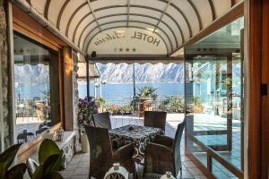 a restaurant with a table and a view of the mountains at Hotel Astoria - 3stelle S in Malcesine