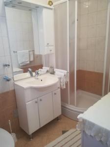 a white bathroom with a sink and a shower at Apartments Jelić in Banići