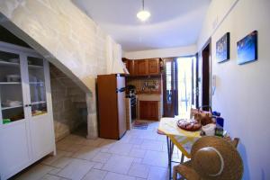 a kitchen with a table and a refrigerator at Dimora Storica San Giovanni in Zollino