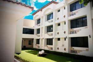 un gran edificio blanco con un patio verde en EH Ejecutivo Urban, en Tepic