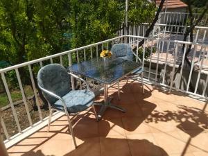 two chairs and a table on a balcony at Apartments Jelić in Banići