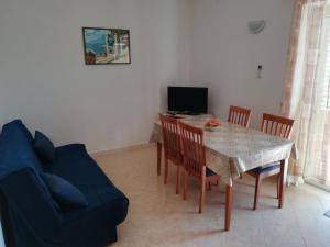 a living room with a table and a blue couch at Apartments Jelić in Banići